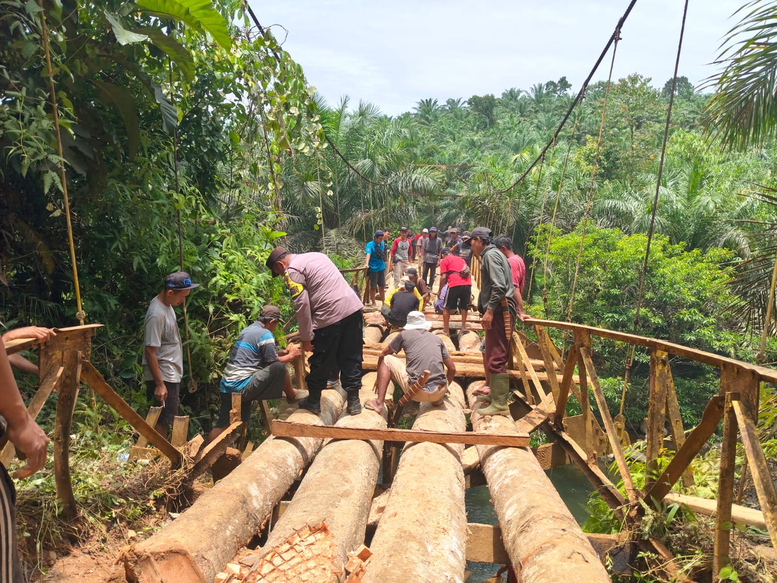 Bhabinkamtibmas Polsek Padang Jaya Bersama Masyarakat Gotong Royong Perbaiki Jembatan Gantung